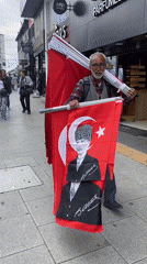 Man carries Turkish flags on busy Kadıköy street