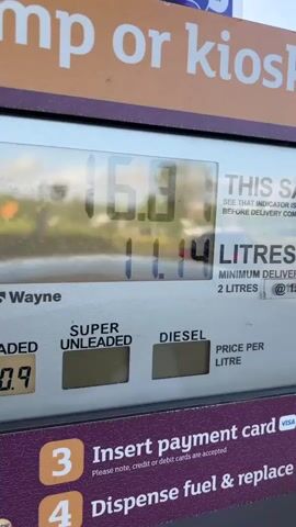 The video shows a close-up of a gas pump display while fuel is being dispensed. The numbers on the display are changing, showing the amount of money and the number of litres being pumped. The price per litre for unleaded gas is displayed as 150.9. Instructions on the pump direct the user to insert a payment card and dispense fuel. The pump is a Wayne brand.