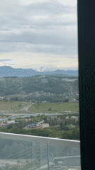 Morning balcony view captures Sochi's green hills and homes