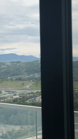 Morning balcony view captures Sochi's green hills and homes