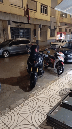 Motorcycles parked on wet street in Meknes after rain