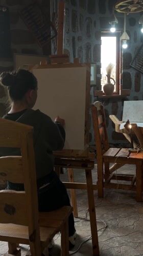 Artist sketches on canvas in stone-walled studio in Armenia