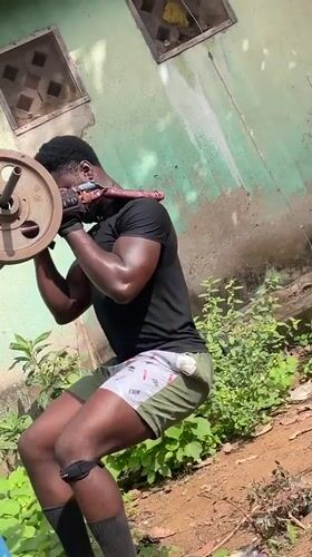 Man performs barbell squat workout in Akwanga, Nigeria
