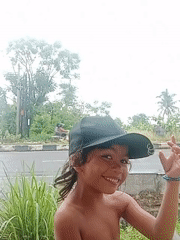 Child photographed on roadside in Lhokseumawe under cloudy skies