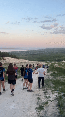 Group walks hillside paths in Khvalynsk during afternoon outing