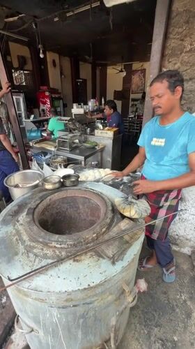 Baker prepares fresh dough at tandoor oven in Delhi