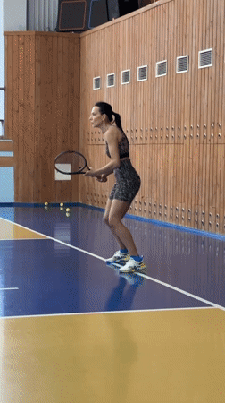 Woman plays early morning tennis in Russian gymnasium