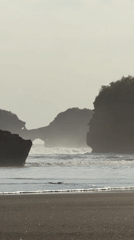 Beach visitors enjoy morning at Bali's dark sand shores