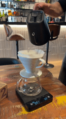 Man prepares pour-over coffee with precision equipment in Tarquinia