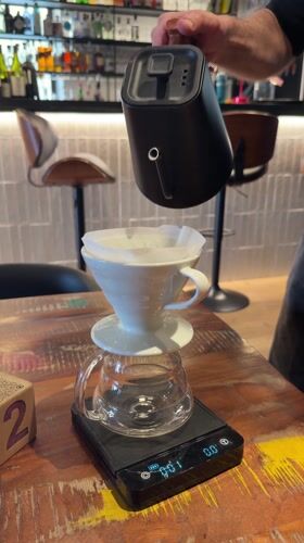 Man prepares pour-over coffee with precision equipment in Tarquinia
