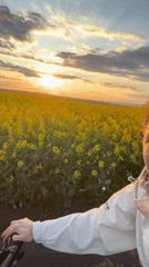 Woman poses in canola field at sunset in Burgas