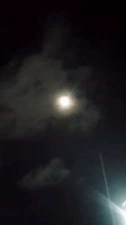 Full moon rises over a cloudy night in Caracas