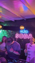 DJ set at Club Soda with neon lighting and dancing crowd