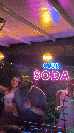 DJ set at Club Soda with neon lighting and dancing crowd