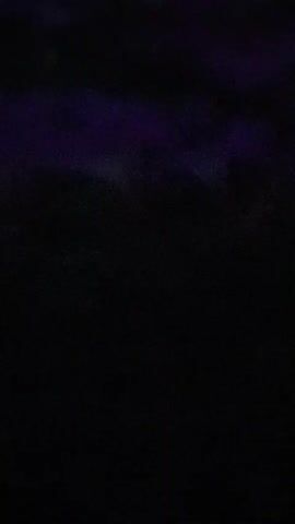 A dark video captures abstract, swirling patterns of purple and black. The image is blurry and lacks any discernible subjects or clear details.