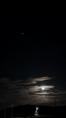 Full moon observed through clouds in nighttime sky
