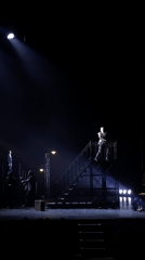 Angel-winged performers stage theatrical production with dramatic lighting