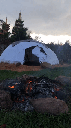 Dome tent and campfire on sandy ground in Mũi Né