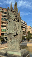 Afternoon street life documented around Barcelona bronze sculpture