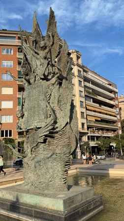 Afternoon street life documented around Barcelona bronze sculpture