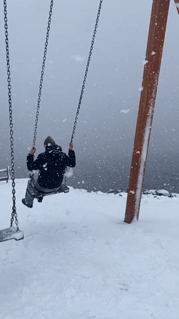 Man swings in heavy snowfall at Murmansk playground