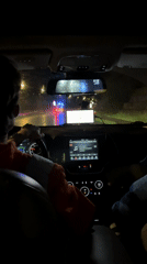 Nighttime drive on wet Batumi road with emergency lights ahead