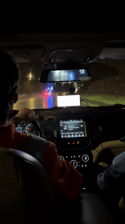 Nighttime drive on wet Batumi road with emergency lights ahead
