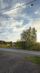 Child plays soccer in rural Russian village during afternoon