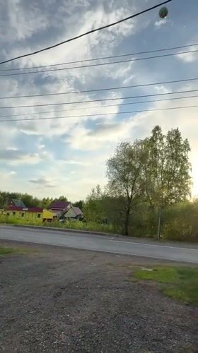 Child plays soccer in rural Russian village during afternoon