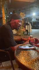 Man sits at outdoor table in Pattaya, appears singing