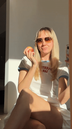 Woman eats apple, takes selfie in Carnikava, Latvia