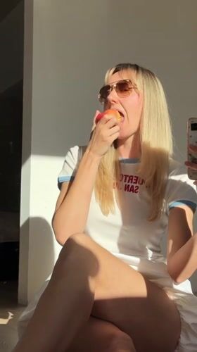 Woman eats apple, takes selfie in Carnikava, Latvia
