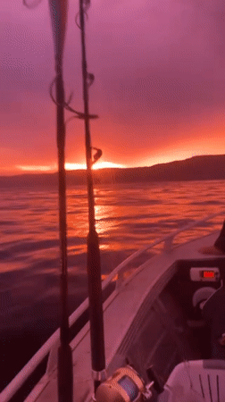 Fishing boat travels through colorful sunset waters near Wombarra