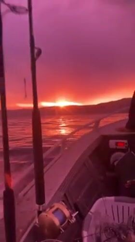 Fishing boat travels through colorful sunset waters near Wombarra
