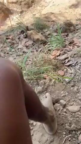 The video begins with a view of the ground covered in leaves and some greenery.  In the background is a small rise with a large white rock formation. The camera then pans upward to reveal a blue sky with scattered clouds. Next, the camera focuses on a dry, grassy hillside. Finally, the view shifts to reveal a quarry-like area with dirt and rock. In the distance, a bulldozer is visible.