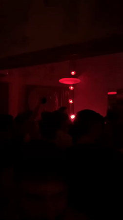Late-night bar scene in Tel Aviv with red lights and a DJ