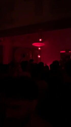 Late-night bar scene in Tel Aviv with red lights and a DJ