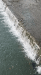 Water flowing over a concrete weir on a Sochi river