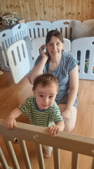 Woman and toddler share playtime with pink rocking toy