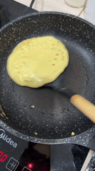 Pancake cooking and colorful wall lighting captured by witnesses