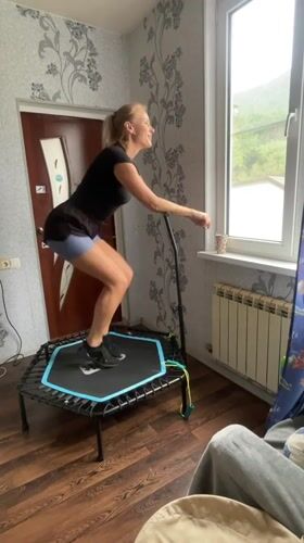 Woman exercises on mini-trampoline in Baranovka home workout session