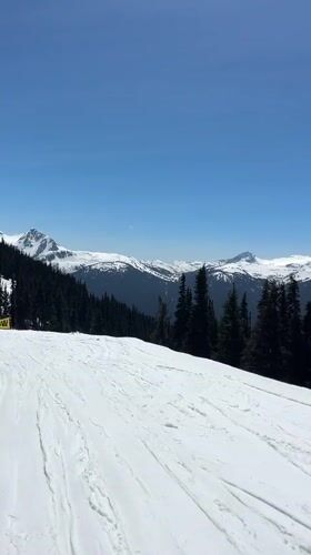 Skier descends slope at Whistler under clear skies