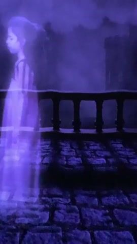 The video shows a dark, purple-tinted scene of a stone-paved courtyard with a stone railing and what appears to be a castle in the background. A translucent, shadowy figure of a person in a striped garment is visible on the left side of the screen. The figure is semi-transparent and appears to be moving or phasing through the scene. The lighting is dim, with a hazy, smoky atmosphere, and a crescent moon is visible in the dark sky. The video appears to be a close-up shot of a backdrop or a scene set for a performance or photography, possibly with a spooky or theatrical theme.