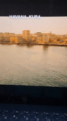Person watches Cuba travel video on laptop in Indonesia