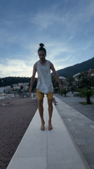 Man performs beach acrobatics on Petrovac promenade wall