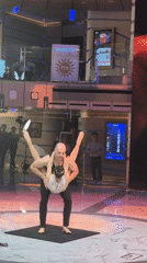 Acrobatic duo performs lift routine on stage