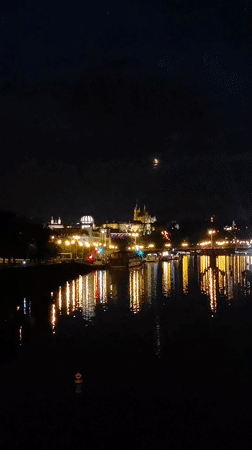 Prague skyline glowing across the water at night