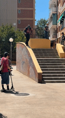 Young men practice scooter tricks in sunny Badalona