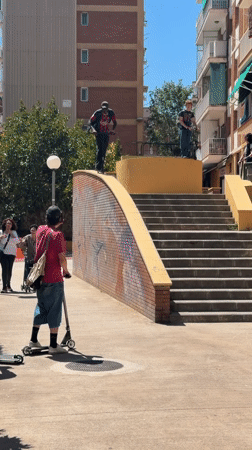 Young men practice scooter tricks in sunny Badalona