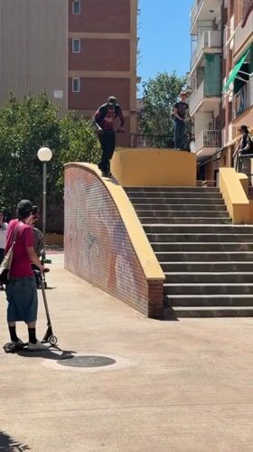 Young men practice scooter tricks in sunny Badalona